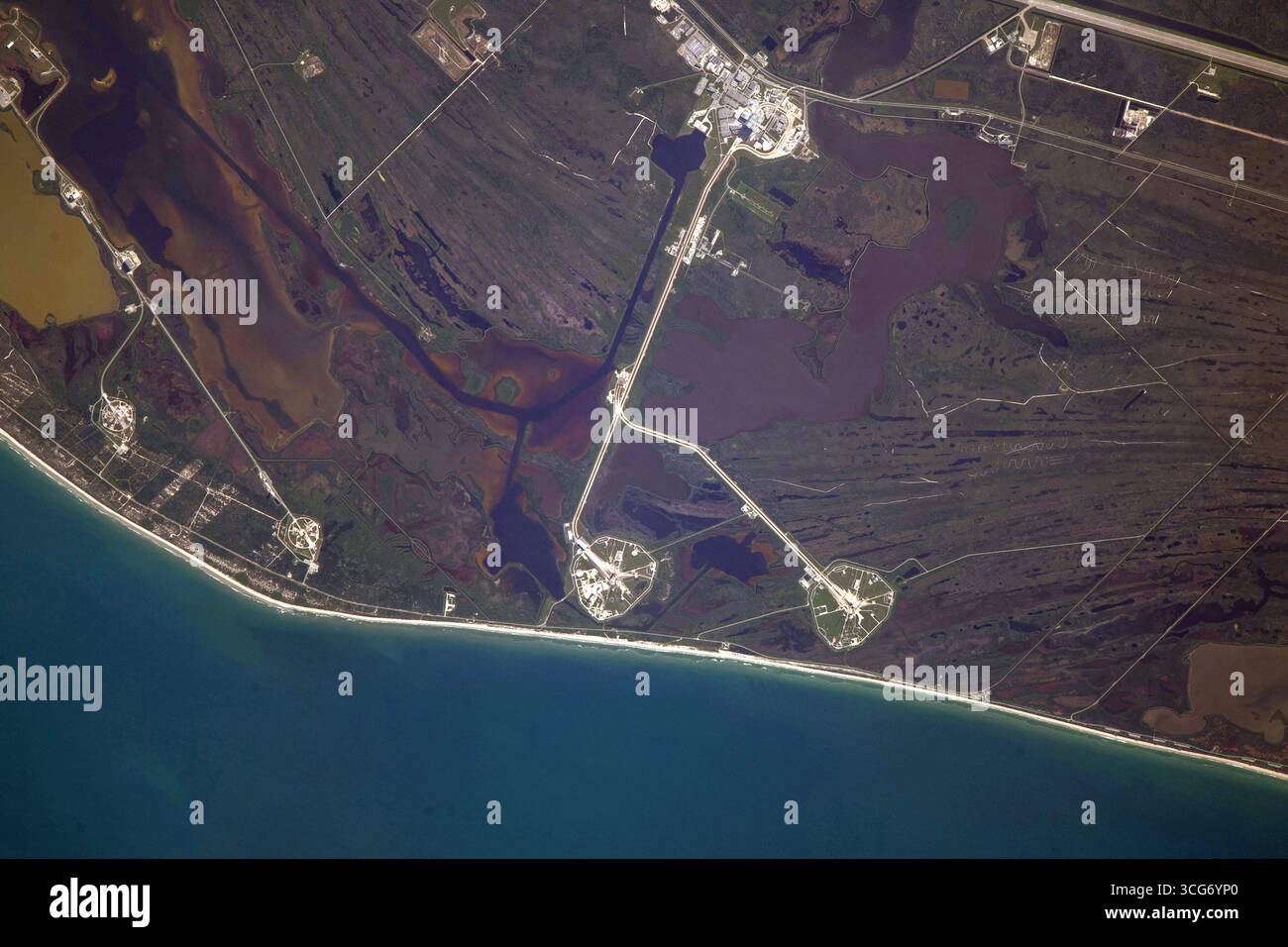 Lancia il complesso 39 al Kennedy Space Center, Merritt Island, Florida, Stati Uniti. Piattaforme di lancio, 39A e 39B.. Il Launch Complex 39 è stato utilizzato per molte missioni della NASA, tra cui i programmi Apollo e Space Shuttle. È ora utilizzato anche da società spaziali commerciali come SpaceX. Immagine tratta dalla stazione spaziale Internazionale. Le piattaforme di lancio sono circolari e circondate da canali. Questi canali vengono utilizzati per trasportare razzi e altre attrezzature alle piattaforme di lancio. Una versione ottimizzata di un'immagine ISS originale: Credit: NASA Foto Stock Lancia il complesso 39 al Kennedy Space Center, Merritt Island, Florida, Stati Uniti. Piattaforme di lancio, 39A e 39B.. Il Launch Complex 39 è stato utilizzato per molte missioni della NASA, tra cui i programmi Apollo e Space Shuttle. È ora utilizzato anche da società spaziali commerciali come SpaceX. Immagine tratta dalla stazione spaziale Internazionale. Le piattaforme di lancio sono circolari e circondate da canali. Questi canali vengono utilizzati per trasportare razzi e altre attrezzature alle piattaforme di lancio. Una versione ottimizzata di un'immagine ISS originale: Credit: NASA Foto Stock