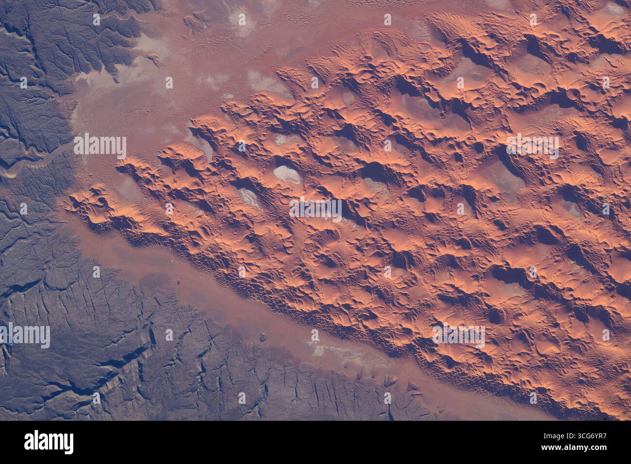 Dune di sabbia nel deserto del Sahara. Il vento forma un'importante rete di dune di sabbia in parte del deserto del Sahara mentre la stazione spaziale Internazionale orbita a circa 260 miglia sopra l'Algeria. Ogni anno, si stima che 100 milioni di tonnellate di polvere vengano raccolte dai venti nella zona. 18 settembre 2023 una versione ottimizzata di un'immagine originale della NASA: Credit NASA/AMogensen Foto Stock