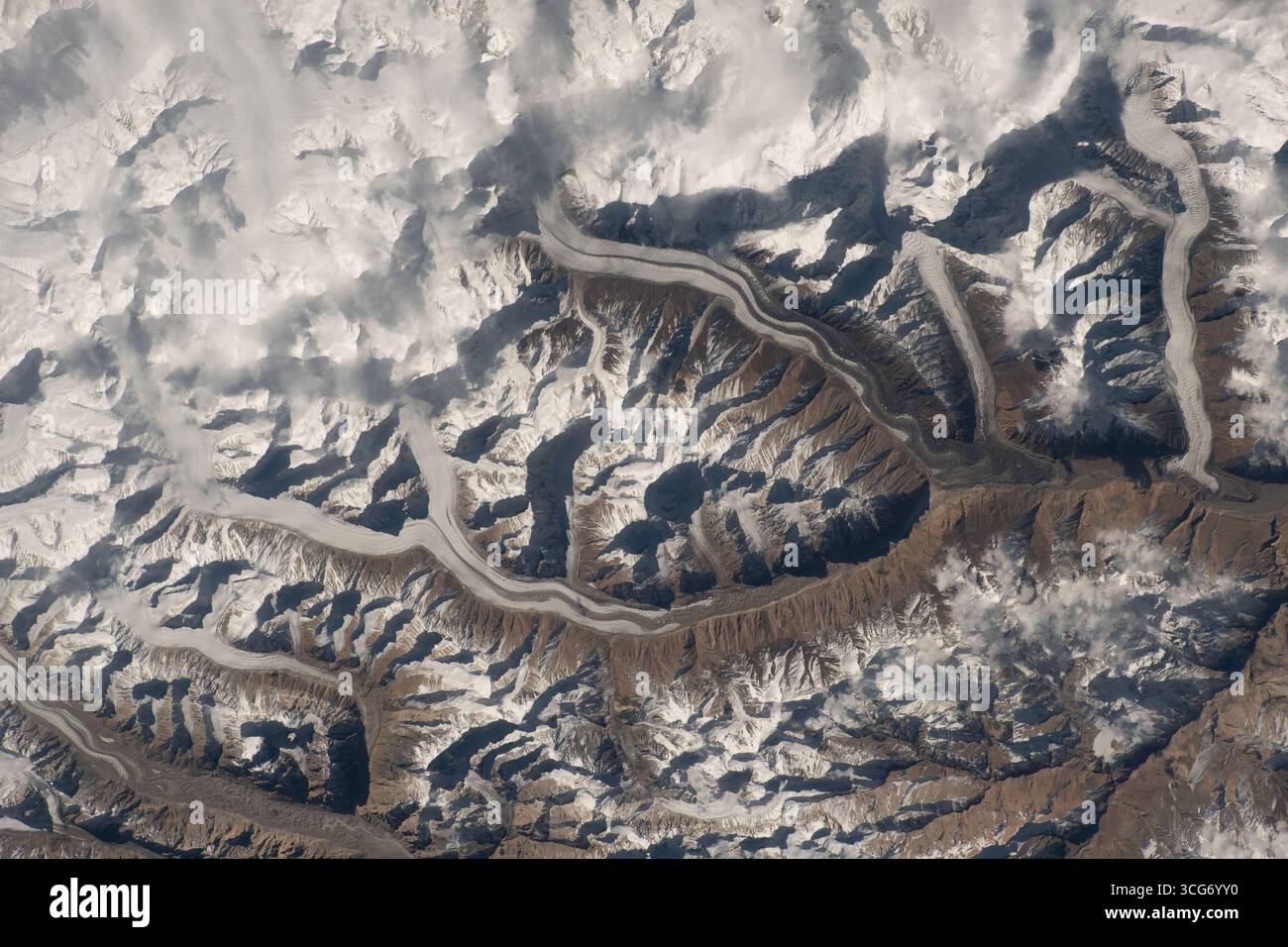 Neve nella catena montuosa del Karakoram. La neve si snoda attraverso la catena montuosa del Karakoram mentre le nuvole sospese si fondono nelle cime innevate delle montagne mentre la stazione spaziale Internazionale si innalza a 259 km sopra il Pakistan. 2 dicembre 2023 una versione ottimizzata di un'immagine ISS originale: Credito: NASA/JAXA/SFurukawa. Solo per uso editoriale. Foto Stock