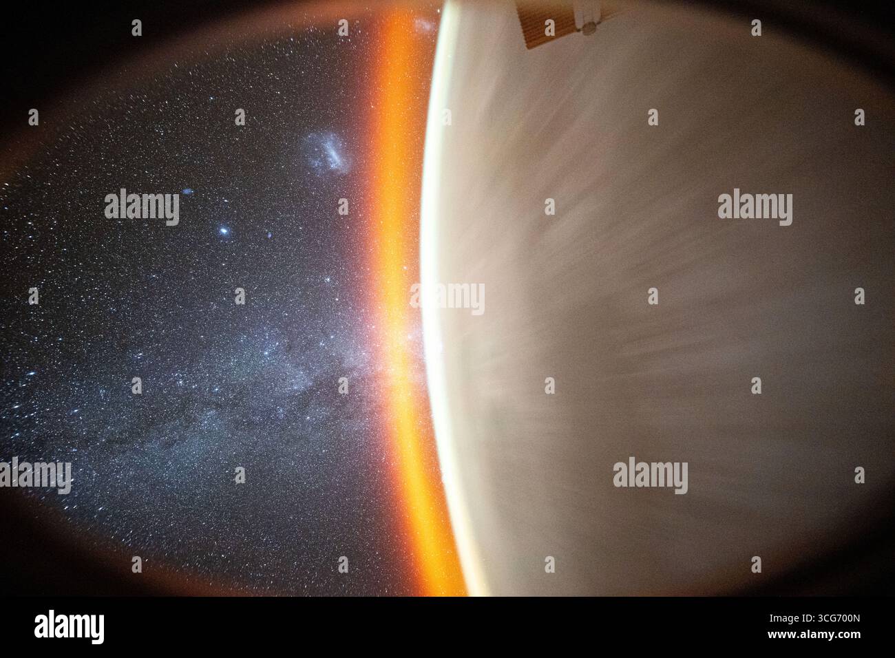 Questa immagine celeste catturata dall'astronauta della NASA Don Pettit utilizza una telecamera con impostazioni di scarsa illuminazione e lunga durata e mostra la via Lattea oltre l'orizzonte della Terra coronata da un bagliore atmosferico. Le grandi e piccole nuvole di Magellano si distinguono anche come la stazione spaziale Internazionale orbitata sopra l'Oceano Pacifico. Una versione ottimizzata di un'immagine originale della NASA: Credito: NASA/DPettit Foto Stock