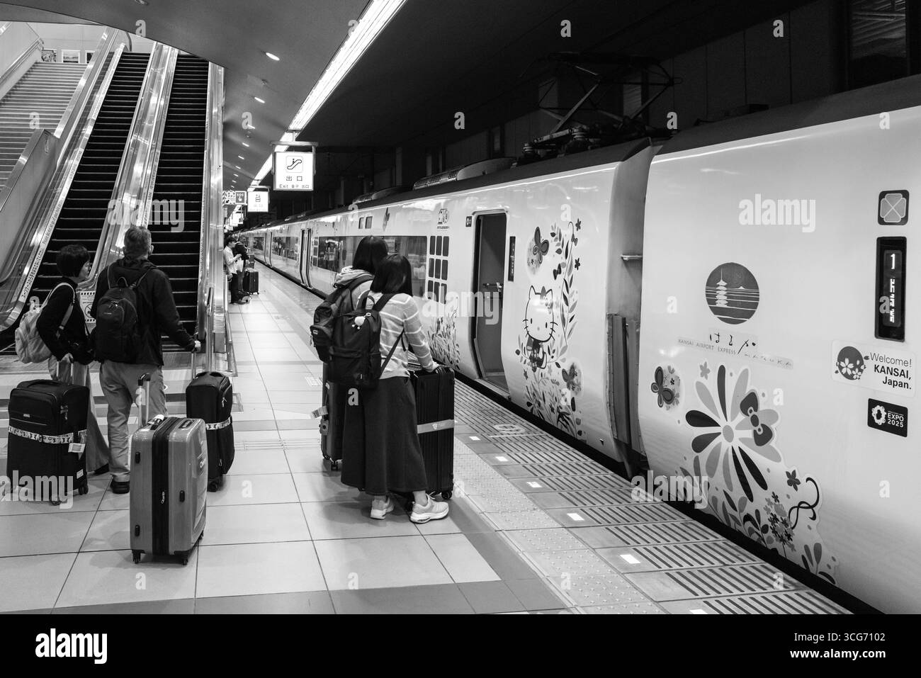 I viaggiatori che salgono a bordo di un treno espresso Kansai Hello Kitty Haruka, decorato con opere d'arte decorative, al binario della stazione dell'aeroporto di Kansai, Kansai Internationa Foto Stock