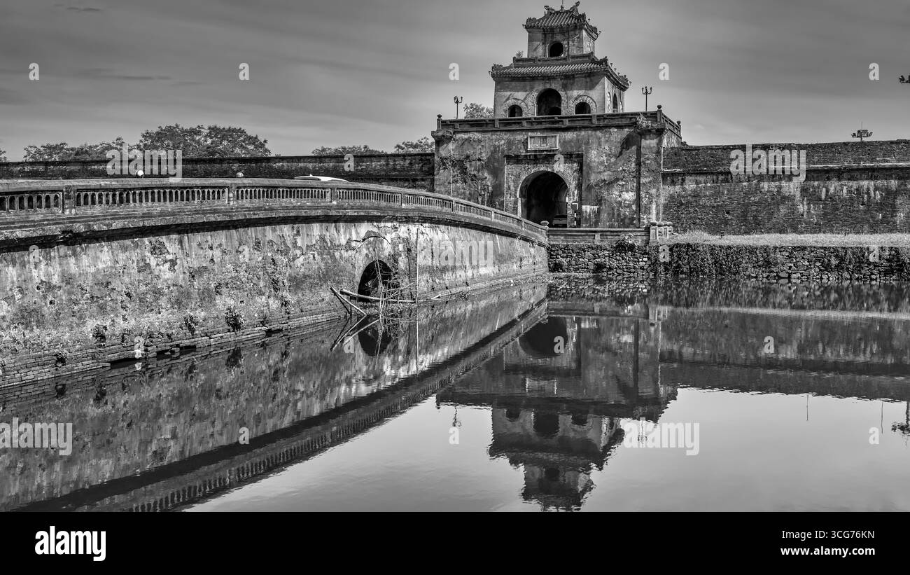 Vista panoramica della porta di Ngan nelle mura della fortezza della Cittadella e un ponte sul fossato che circonda la città imperiale con la città Proibita viola, Hue Foto Stock