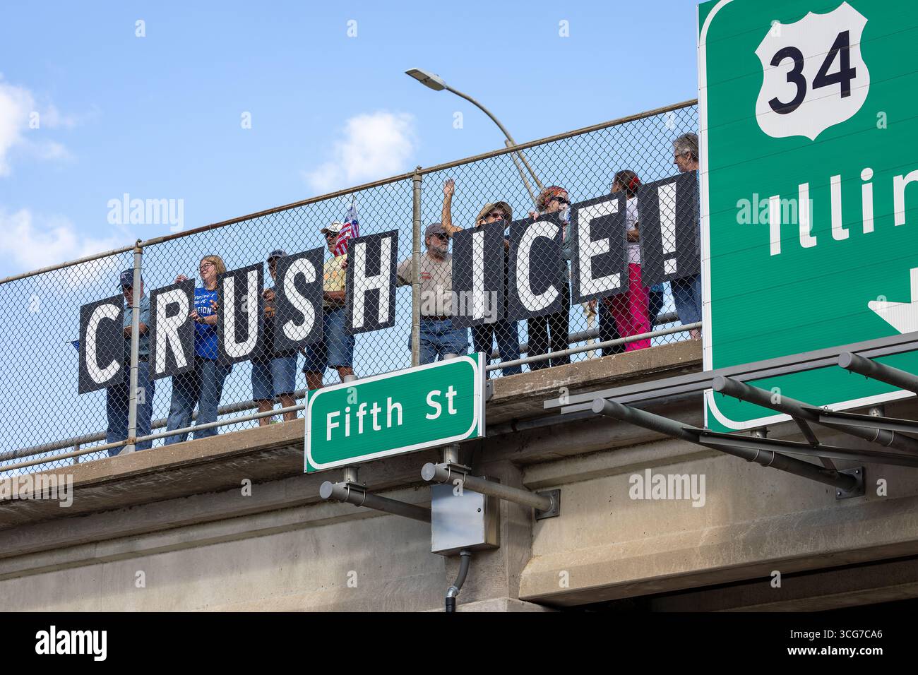 Burlington, Iowa, Stati Uniti. 26 agosto 2025. Gli attivisti politici del gruppo indivisibile dell'Iowa hanno tenuto segnali di "SCHIACCIAMENTO DEL GHIACCIO" su un cavalcavia autostradale per protestare contro la politica di applicazione dell'immigrazione degli Stati Uniti. Credito: Keith Turrill/Alamy Live News Foto Stock