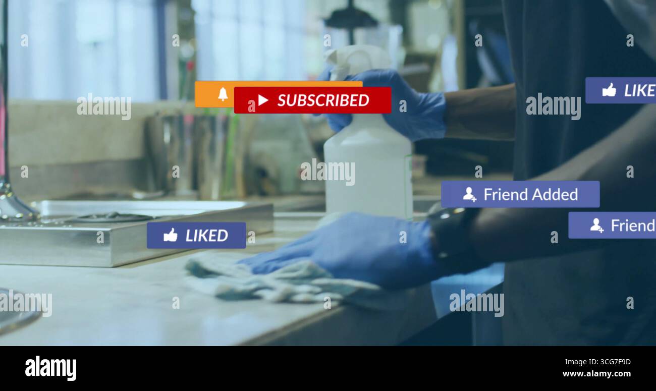 Pulizia di un adulto maschio con guanti blu che puliscono il piano di lavoro in cucina, con flacone spray e panno Foto Stock