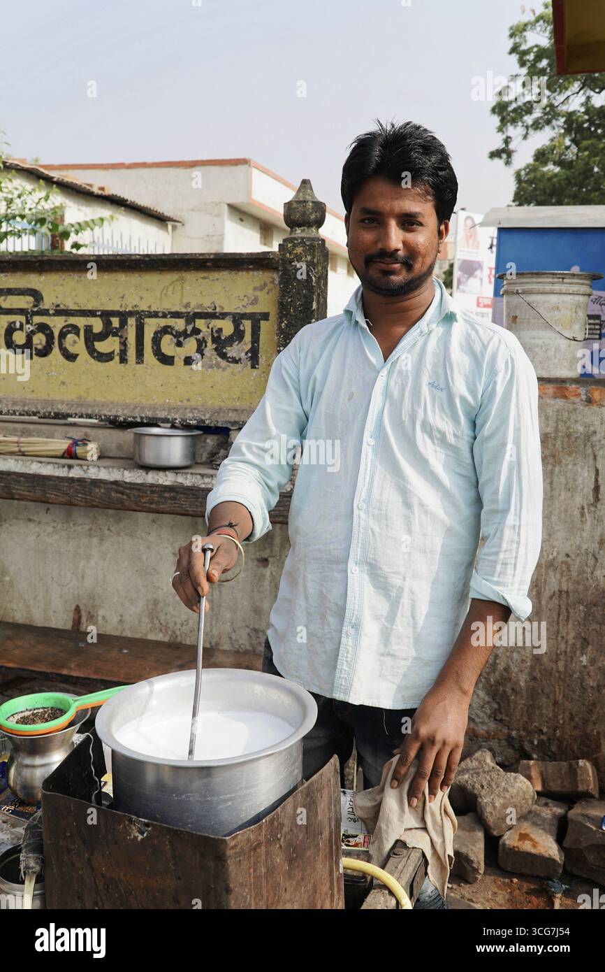 Kota, Rajasthan, India del Nord, Asia, Un venditore che fa bollire il latte in un vaso per strada in una zona rurale, l'India Foto Stock