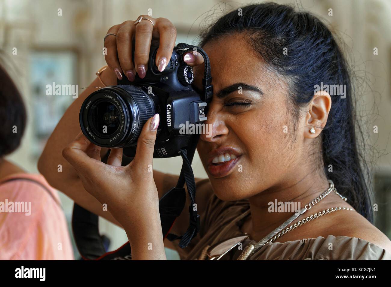 Donna con fotocamera in mano che scatta foto in un interno, Udaipur, Rajasthan, India settentrionale Foto Stock