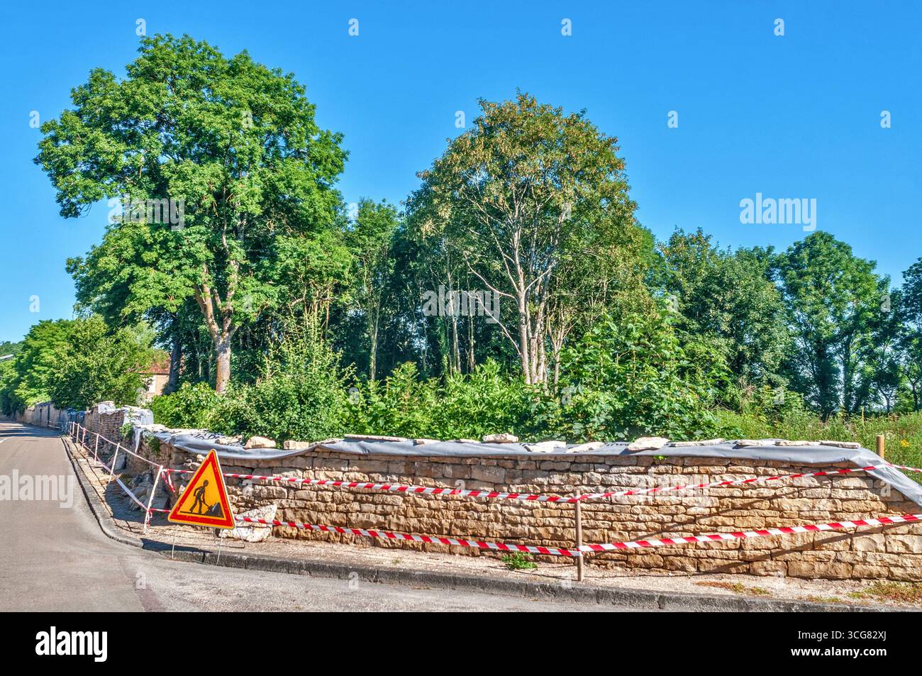 Tradizionalmente costruisci un muro di pietra locale all'angolo della strada - Yonne (89), Francia. Foto Stock