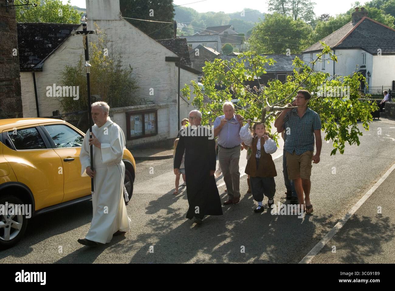Oak Apple Day Regno Unito. 29 maggio in Cornovaglia, Inghilterra. Un ramo di legno di quercia viene trasportato attraverso il villaggio guidato dal Revd. Phillip Biggs fino alla chiesa di St. Neot, dove viene issata in cima alla torre della chiesa. Conosciuto anche come Royal Oak o Restoration Day, il 29 maggio è la celebrazione del restauro del re Carlo II al trono di Inghilterra, Scozia e Irlanda nel 1651. St Neot, Cornovaglia anni '2016 2010, Regno Unito, HOMER SYKES Foto Stock
