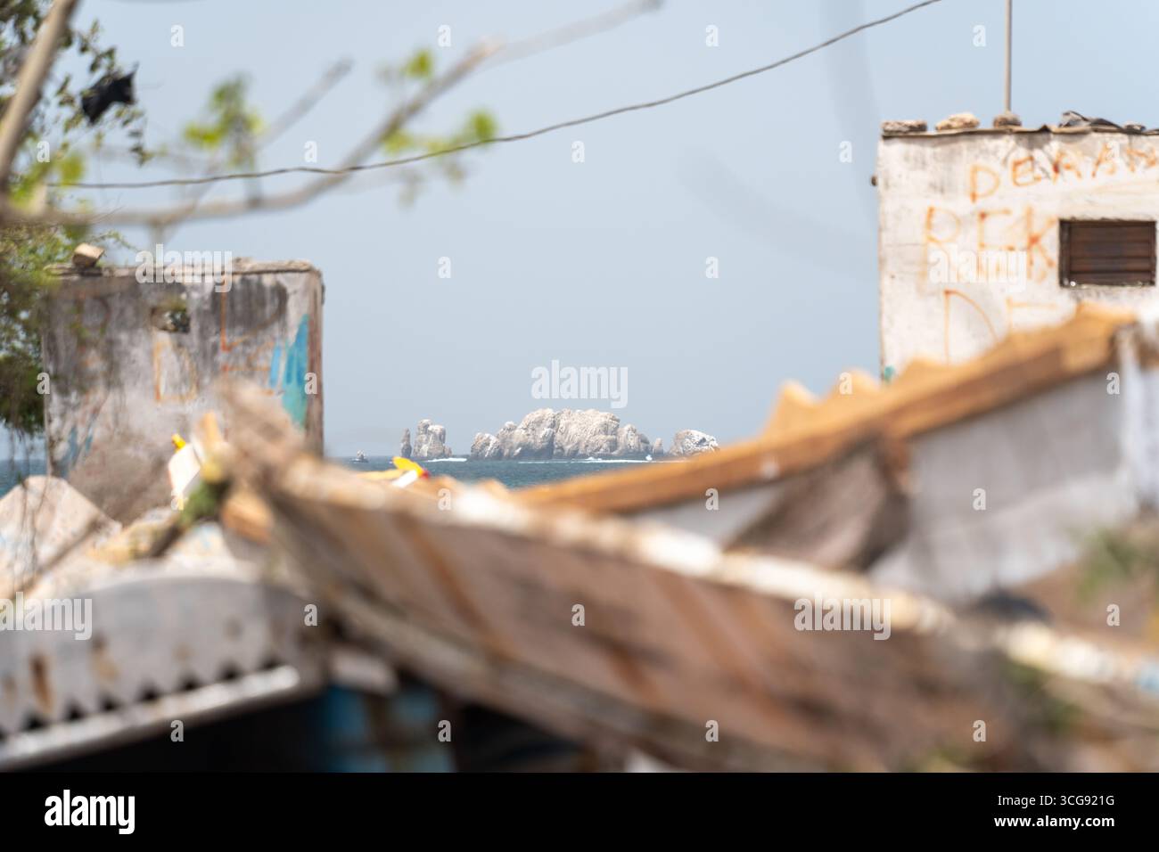 Dakar, Senegal - 12 maggio 2025: Veduta del lontano Îles de la Madeleine, che sorge dal mare, incorniciato da edifici intemprati a Plage de Soumbédioune. Foto Stock