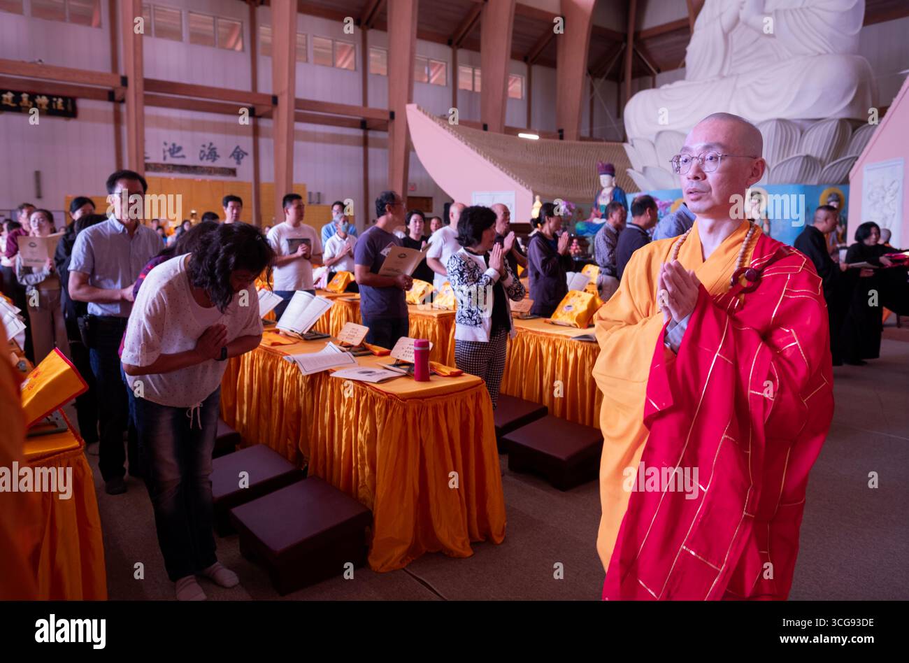CERIMONIA ULLAMBANA Un monaco conduce i fedeli fuori a bruciare denaro fantasma che onora e benedice i defunti nell'aldilà. In un monastero settentrionale Foto Stock