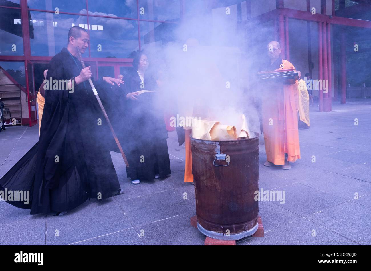 I monaci buddisti bruciano soldi del cielo che onora e benedice i defunti nell'aldilà. In un tempio a Carmel, Putnam Valley, New York. Foto Stock