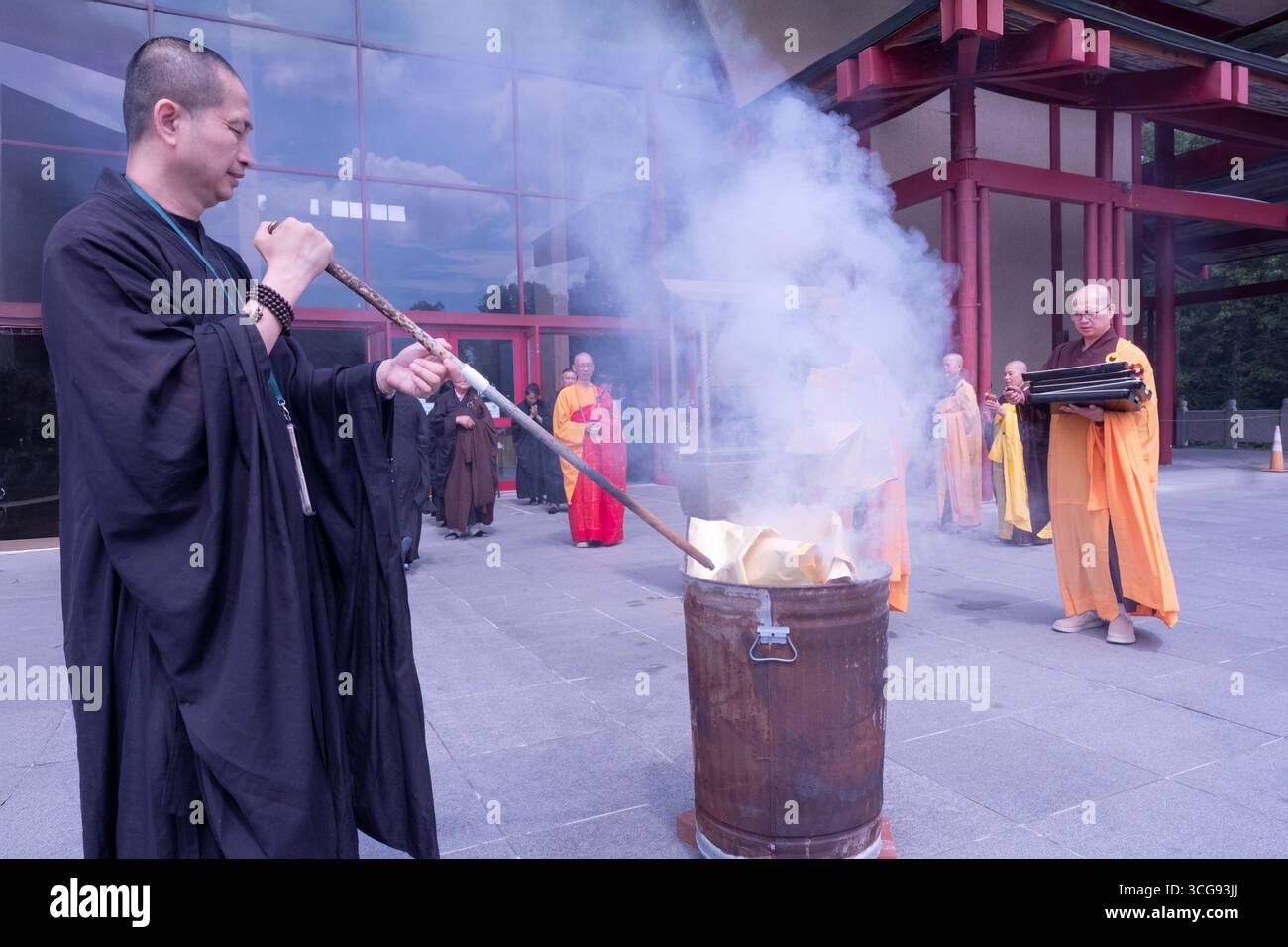 I monaci buddisti bruciano denaro imitato che onora e benedice i defunti nell'aldilà. In un tempio a Carmel, Putnam Valley, New York. Foto Stock