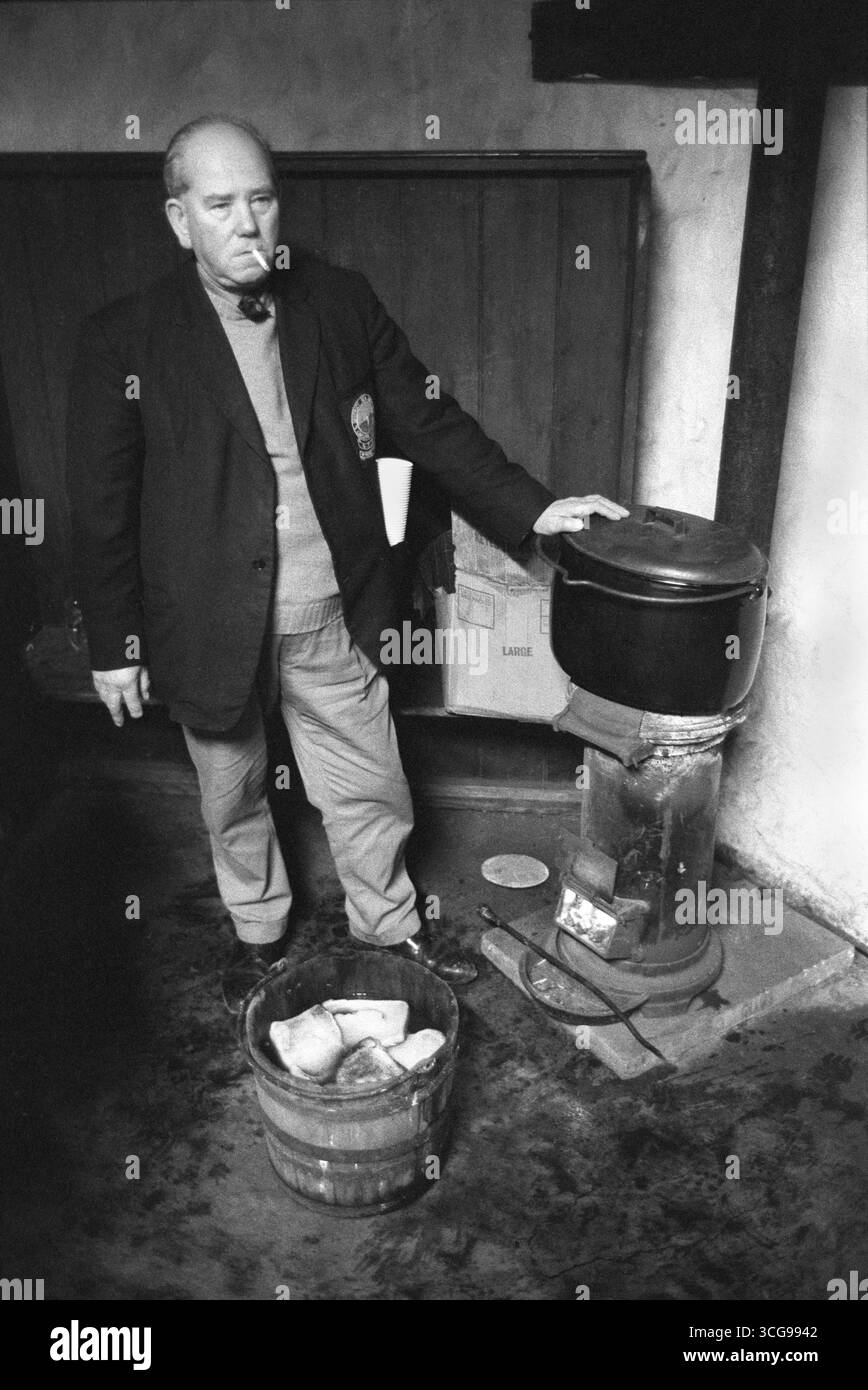 Wassailing the Apple Tree, Carhampton Somerset. Si sta preparando un barile di sidro riscaldato con pane tostato e un altro recipiente di sidro caldo. Il sidro caldo con toast verrà passato intorno ai presenti. La salute dell'albero è ubriaca, e brindisi messo nei rami, presumibilmente per gli uccelli che, si spera, terranno un occhio vigile e benevolo sull'albero per l'anno successivo. I Wassailers cantano la canzone delle wassail i musicisti suonano la fisarmonica. Inghilterra anni '1972 1970 Regno Unito HOMER SYKES Foto Stock