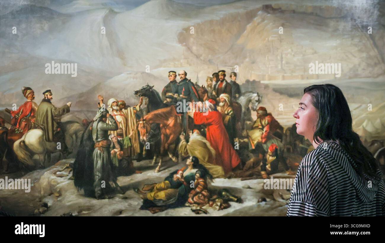 Londra, Regno Unito. 27 agosto 2025. Personale del museo con "la capitolazione di Kars, 28 novembre 1855" (1857) di Thomas Jones Barker, un'opera in questa mostra. Il National Army Museum ha commissionato ad artisti contemporanei di reinterpretare iconici dipinti militari vittoriani nella mostra "Myth and Reality: Military Art in the Age of Queen Victoria" presso il museo. Crediti: Imageplotter/Alamy Live News Foto Stock