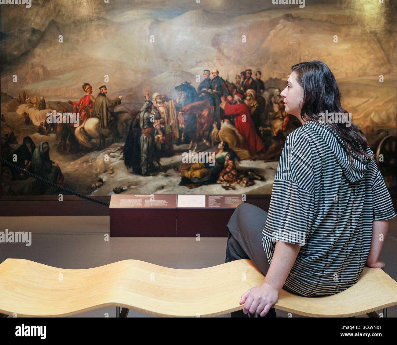 Londra, Regno Unito. 27 agosto 2025. Personale del museo con "la capitolazione di Kars, 28 novembre 1855" (1857) di Thomas Jones Barker, un'opera in questa mostra. Il National Army Museum ha commissionato ad artisti contemporanei di reinterpretare iconici dipinti militari vittoriani nella mostra "Myth and Reality: Military Art in the Age of Queen Victoria" presso il museo. Crediti: Imageplotter/Alamy Live News Foto Stock