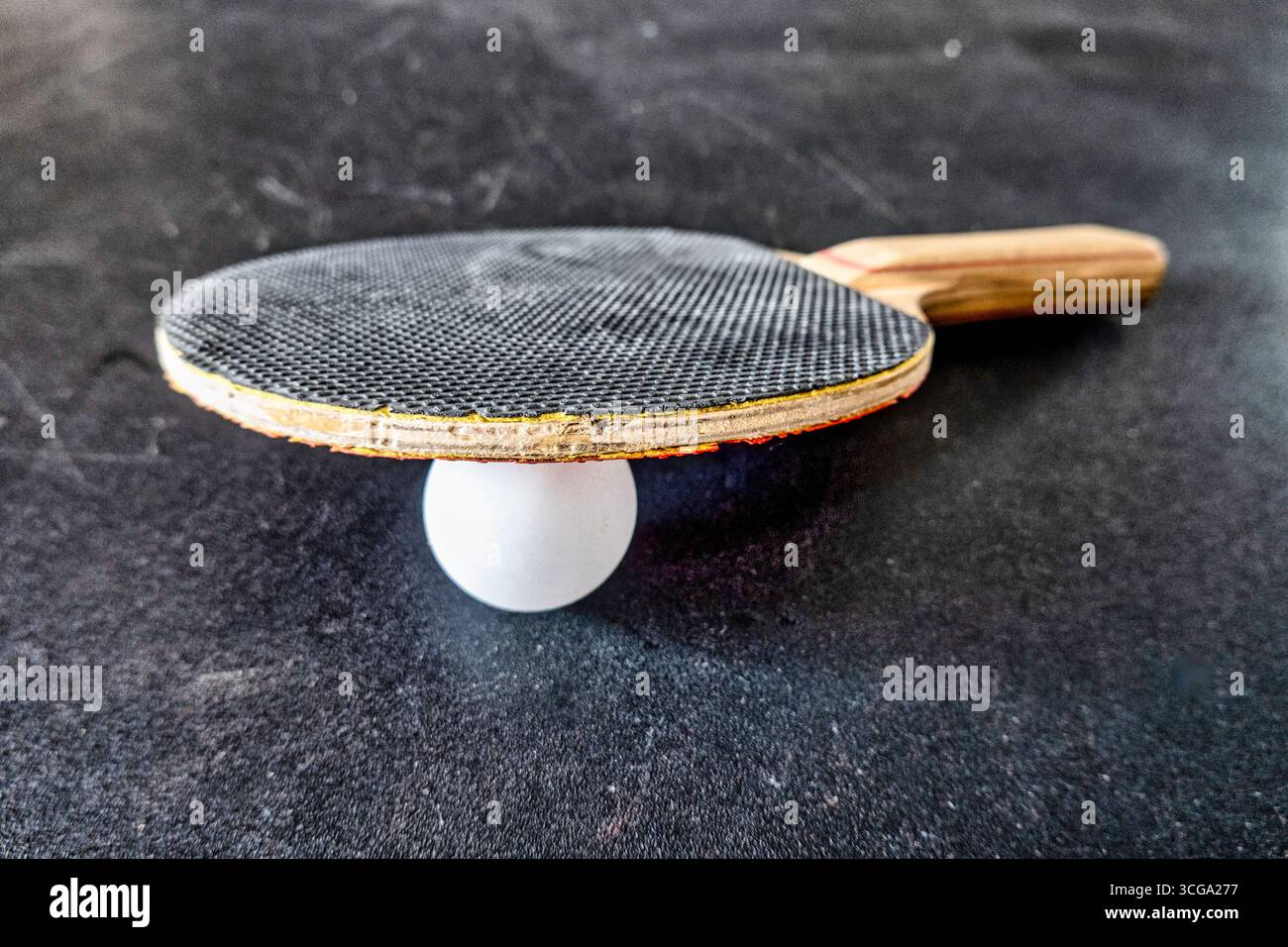 Usato e molto amato ping pong paddle e palla su un tavolo da ping-pong, 2025, Stati Uniti Foto Stock