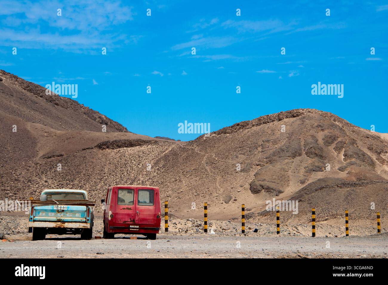 Vecchio camion e furgone, deserti in un paesaggio montano asciutto sotto un cielo azzurro. Foto Stock