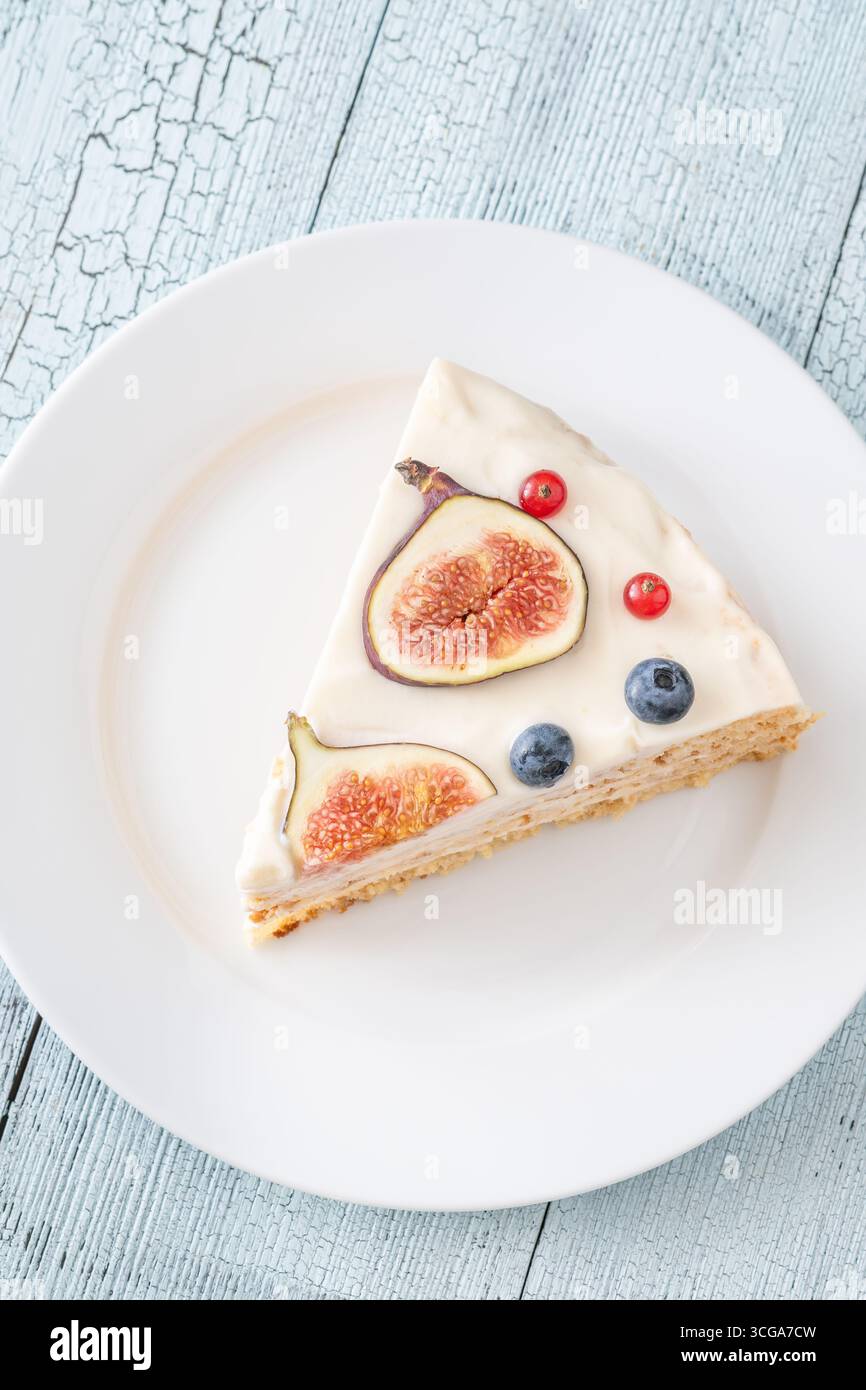 Torta al formaggio spalmabile con spicchi di fichi ribes mirtilli servita con piatto bianco Foto Stock