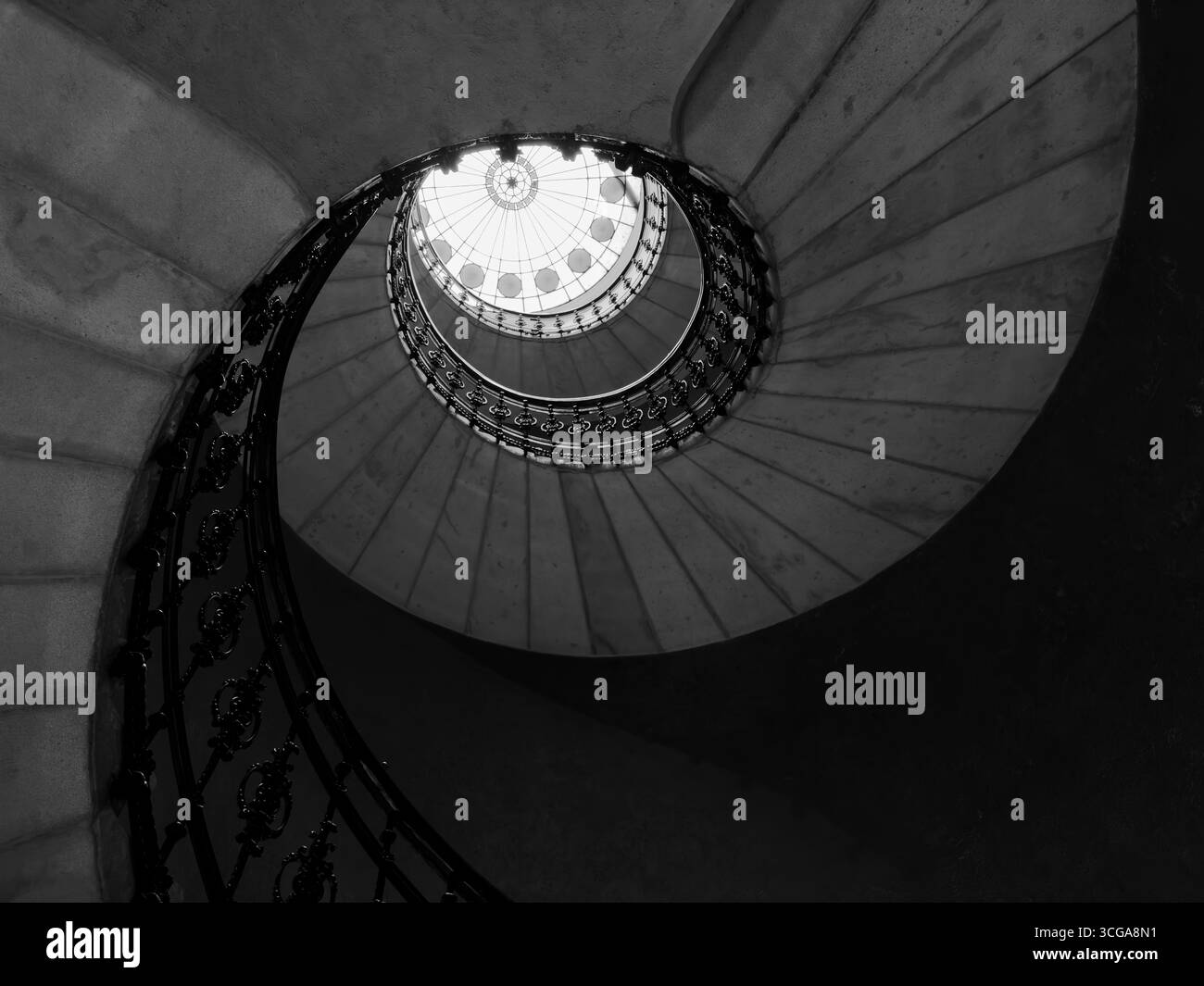 Vista monocromatica della scala a chiocciola con ringhiera in metallo che crea un accattivante motivo geometrico Foto Stock