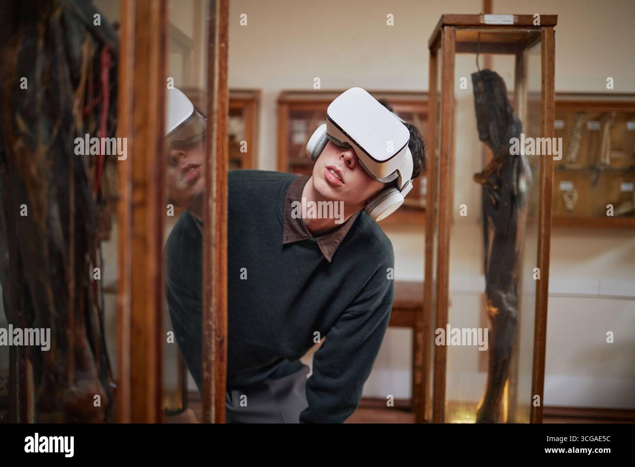 Young Caucasian Man Exploring Museum Exhibit Using Virtual Reality Headset Foto Stock