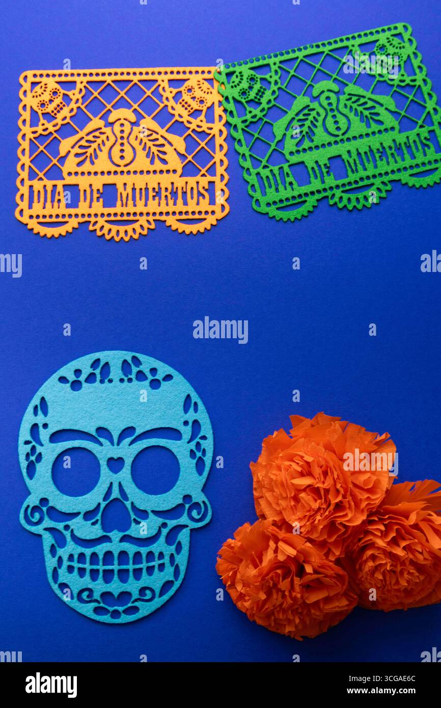 Vivace scena Day of the Dead con il tradizionale picado di papel messicano "Day of the Dead", un teschio decorativo blu ritagliato e fiori di calendula arancioni su una Foto Stock