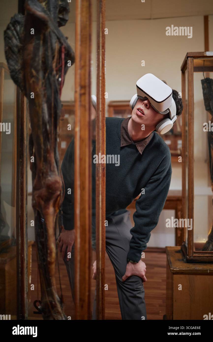 Giovane adulto uomo caucasico che indossa le cuffie per realtà virtuale Explore Museum Foto Stock