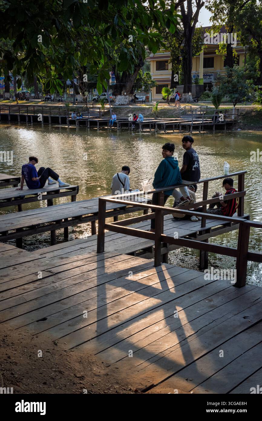 Adolescenti che passano la sera vicino al fiume Siem Reap, Siem Reap, Cambogia Foto Stock