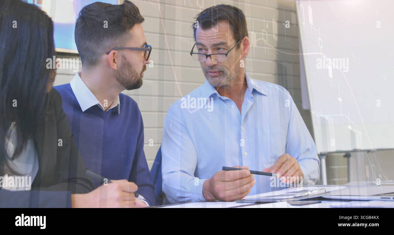 Capo del team senior in maglia blu che guida la discussione del progetto alla scrivania, con documenti stampati Foto Stock