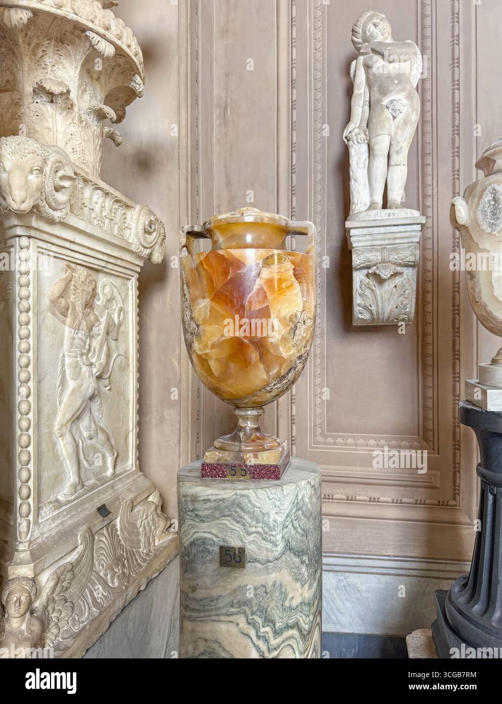 Antica collezione di manufatti e sculture romane con una grande urna di onice su un piedistallo in marmo scanalato all'interno dei Musei Pio-Clementino in Vaticano Foto Stock