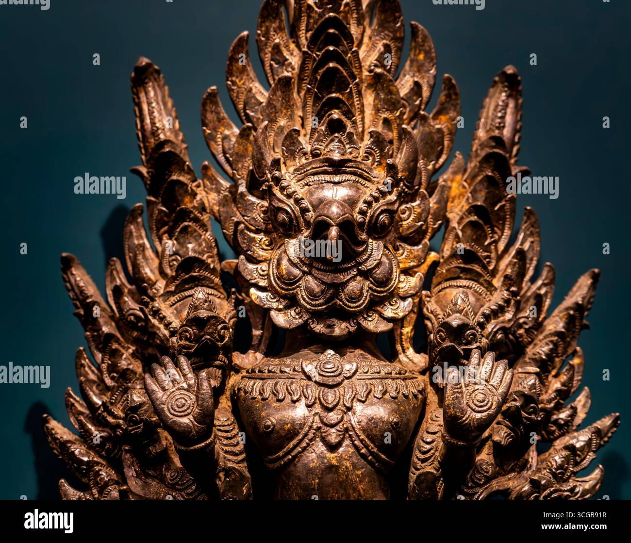 Una dettagliata statua in bronzo raffigurante una creatura mitica con più braccia e un'espressione feroce, che mostra intricate incisioni e disegni decorati Foto Stock