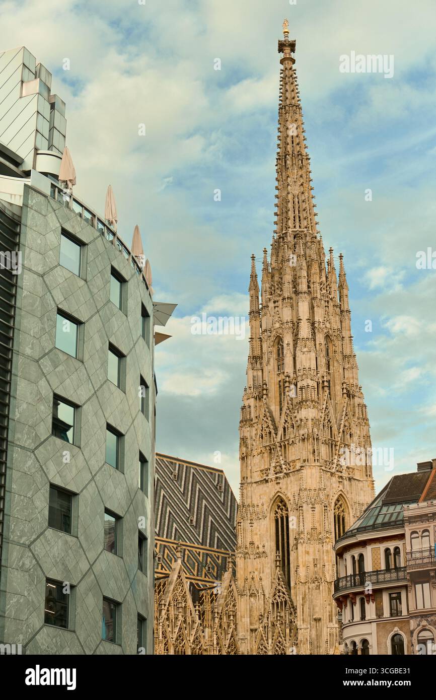 La cupola gotica e il tetto a mosaico della cattedrale di Santo Stefano sono incorniciati da un edificio moderno e da una tradizionale facciata storica, che mette in risalto i contras Foto Stock