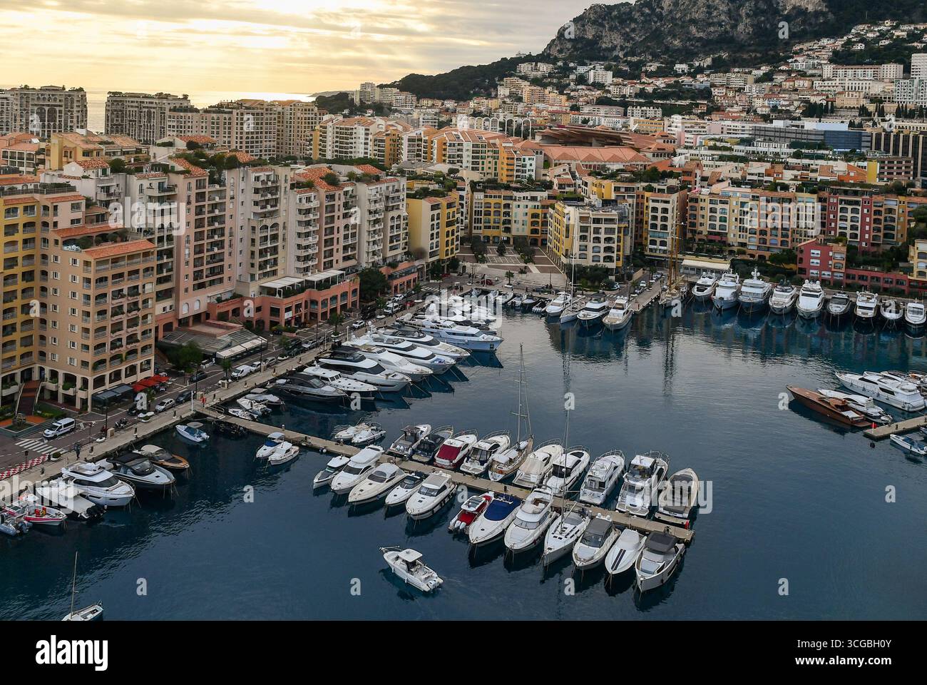 Vista sopraelevata del porticciolo degli yacht del quartiere balneare di Fontvieille, costruito quasi interamente su terreni bonificati artificialmente, al tramonto, nel Principato di Monaco Foto Stock