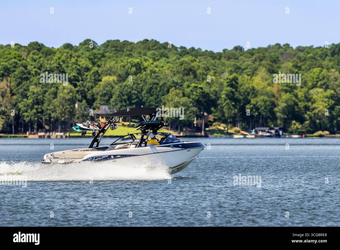 Naviga sul wakeboard Wake ski boat e goditi la giornata estiva sul lago d'acqua dolce. Foto Stock