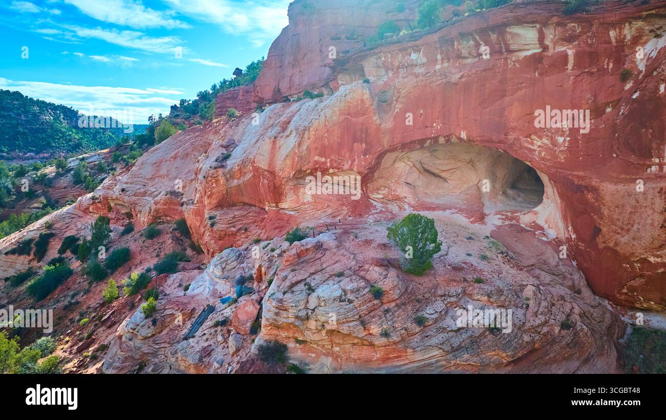 Scogliera aerea di pietra arenaria rossa e grotta naturale con Lone Tree Kanab Utah Foto Stock