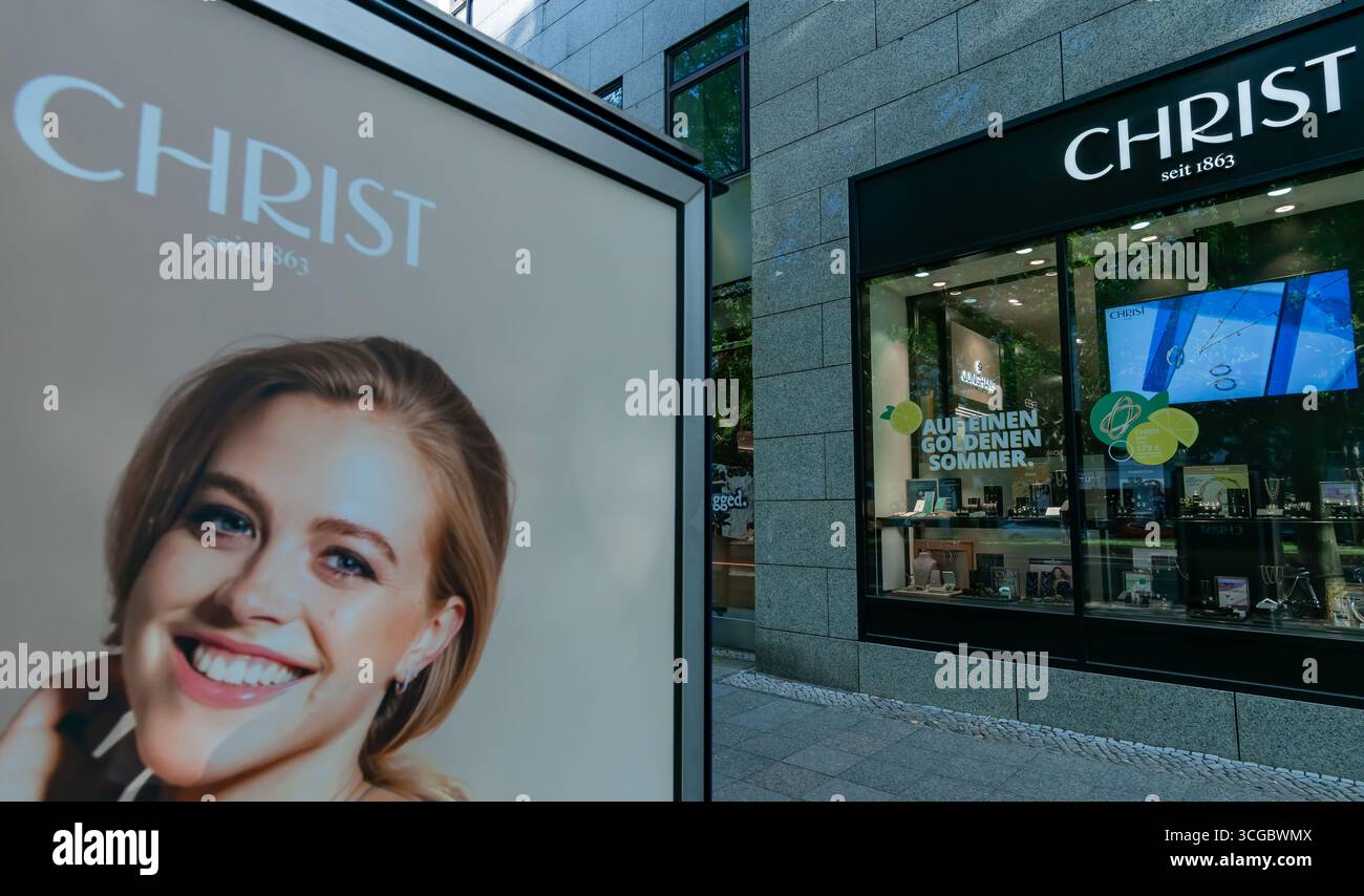 Gioielleria CHRIST a Berlino Kurfürstendamm con pubblicità all'aperto di marca con un modello sorridente sotto la luce naturale. Foto Stock