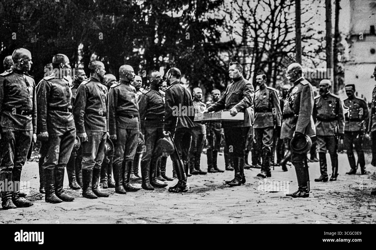Lo zar Nicola II saluta i suoi soldati con il tradizionale bacio pasquale durante la prima guerra mondiale, 1916. Il gesto simbolico del “piccolo padre” della Russia rifletteva profonde tradizioni religiose e culturali, mescolando il rituale ortodosso con il morale bellico. Questa rara fotografia cattura l'Imperatore personalmente onorando le truppe, rafforzando la lealtà durante un periodo di crescenti difficoltà sul fronte orientale. Foto Stock