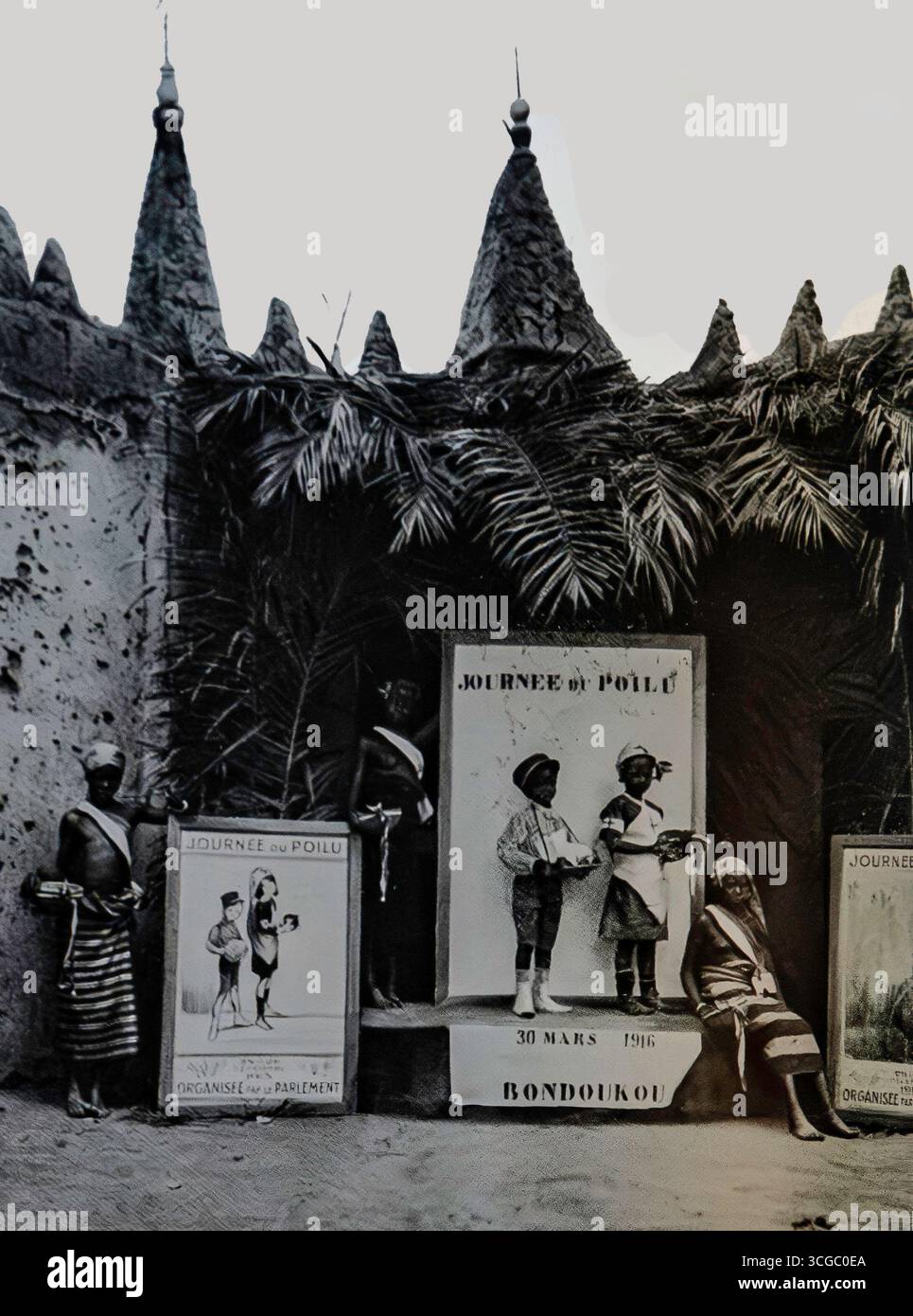 Fotografia tratta da l’Illustration, giugno 1916, che mostra la “Journée du Pullu” a Bondoukou, Côte d’Avorio. I bambini sono accanto ai manifesti in un evento culturale che promuove la fedeltà alla Francia durante la prima guerra mondiale. L'immagine illustra gli sforzi della propaganda coloniale per rafforzare i legami con le comunità musulmane dell'Africa occidentale. Tali incontri riflettevano il ruolo strategico dell'Africa occidentale francese nel fornire risorse e reclute allo sforzo bellico alleato. Foto Stock