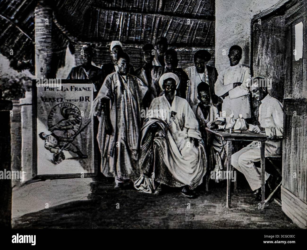 Fotografia di leader e funzionari musulmani a Bondoukou, Côte d’Avorio, pubblicata su l’Illustration, giugno 1916. La scena, ambientata sulla veranda di un ufficio coloniale, mette in risalto l'abbigliamento tradizionale e l'interazione tra le autorità locali e gli amministratori francesi. Durante la prima guerra mondiale, tali manifestazioni di lealtà furono usate per simboleggiare la cooperazione coloniale con la Francia. Questa immagine sottolinea il significato politico dell'Africa occidentale nelle alleanze in tempo di guerra. Foto Stock