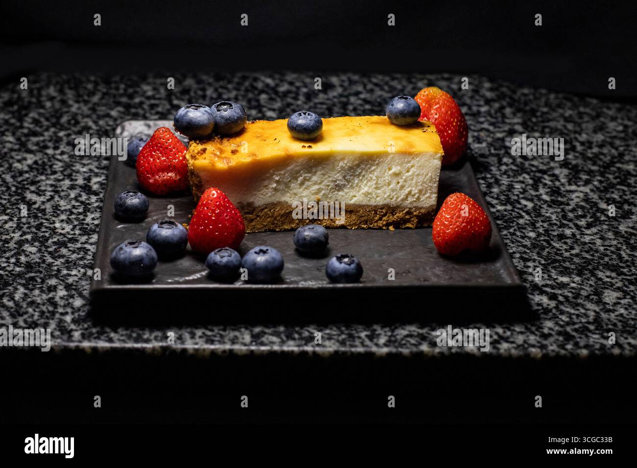 Dessert con frutti di bosco, cheesecake su sfondo nero e spazio per il testo Foto Stock