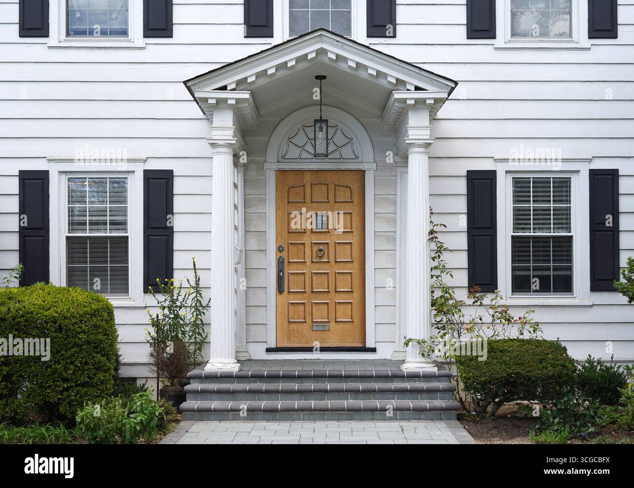 Tradizionale casa in legno bianco a due piani con porta frontale in grana di legno Foto Stock