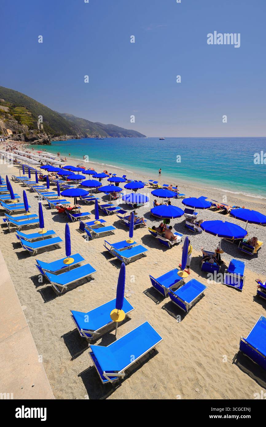 251 lettini e ombrelloni blu, ombrelloni a righe bianco-blu, allineati sulla spiaggia di sabbia e ghiaia. Monterosso al Mare-Liguria. Foto Stock