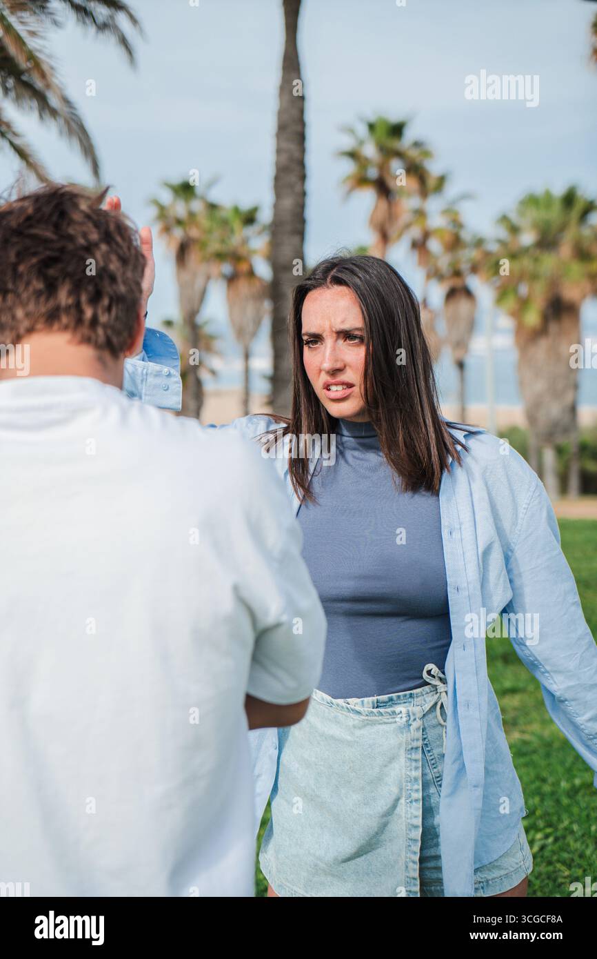 Uno scambio acceso si svolge quando due individui esprimono forti emozioni durante un confronto teso all'aperto, mostrando la complessità delle relazioni Foto Stock