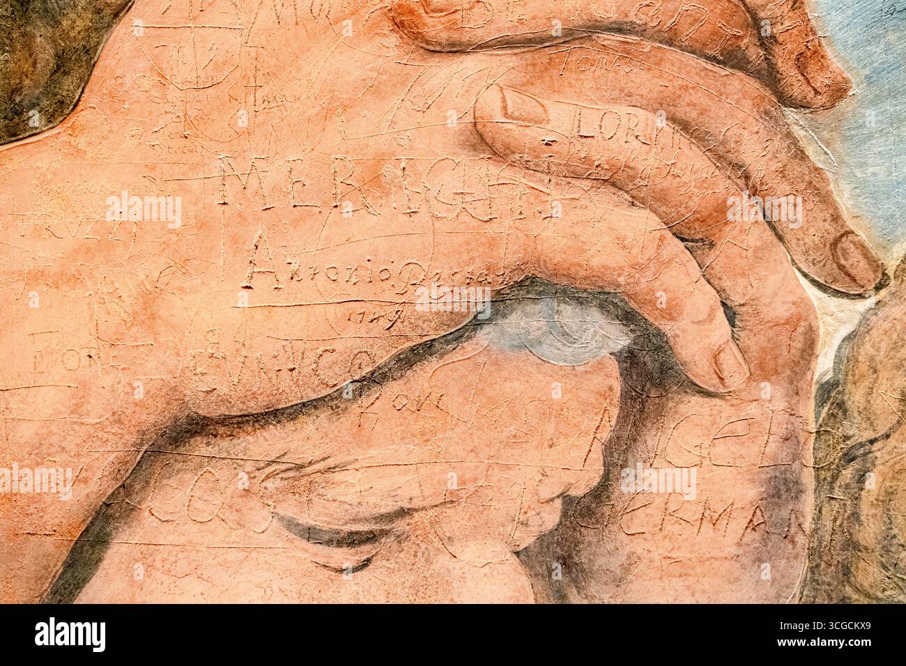 L'immagine di cattura i segni duraturi dei graffiti scolpiti in un'antica superficie affrescata dai visitatori del passato nel corso dei secoli. Mantova, Lombardia. Italia Foto Stock
