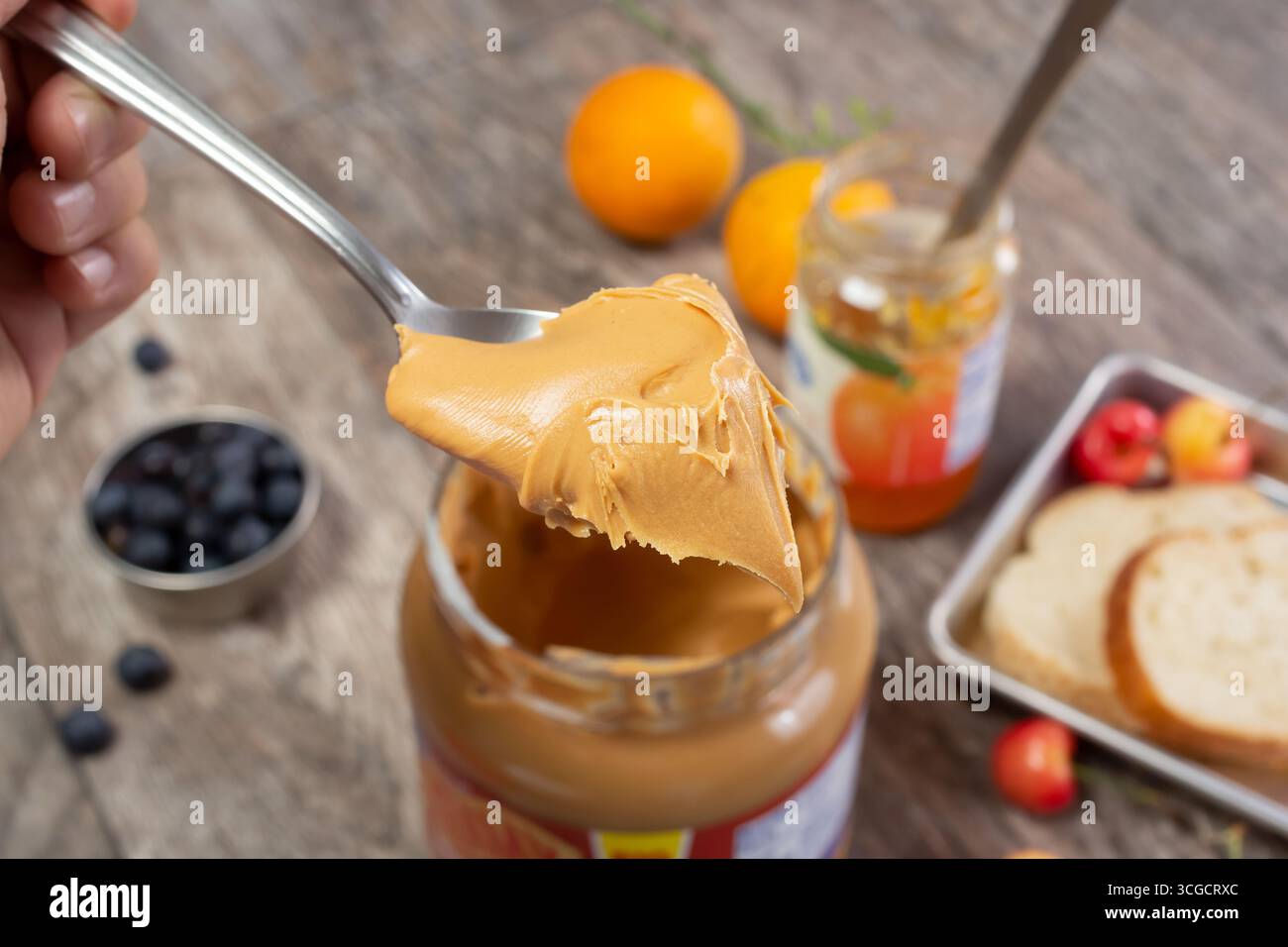 Vista ravvicinata di un cucchiaio pieno di crema burro di arachidi, in un ambiente di vita. Foto Stock