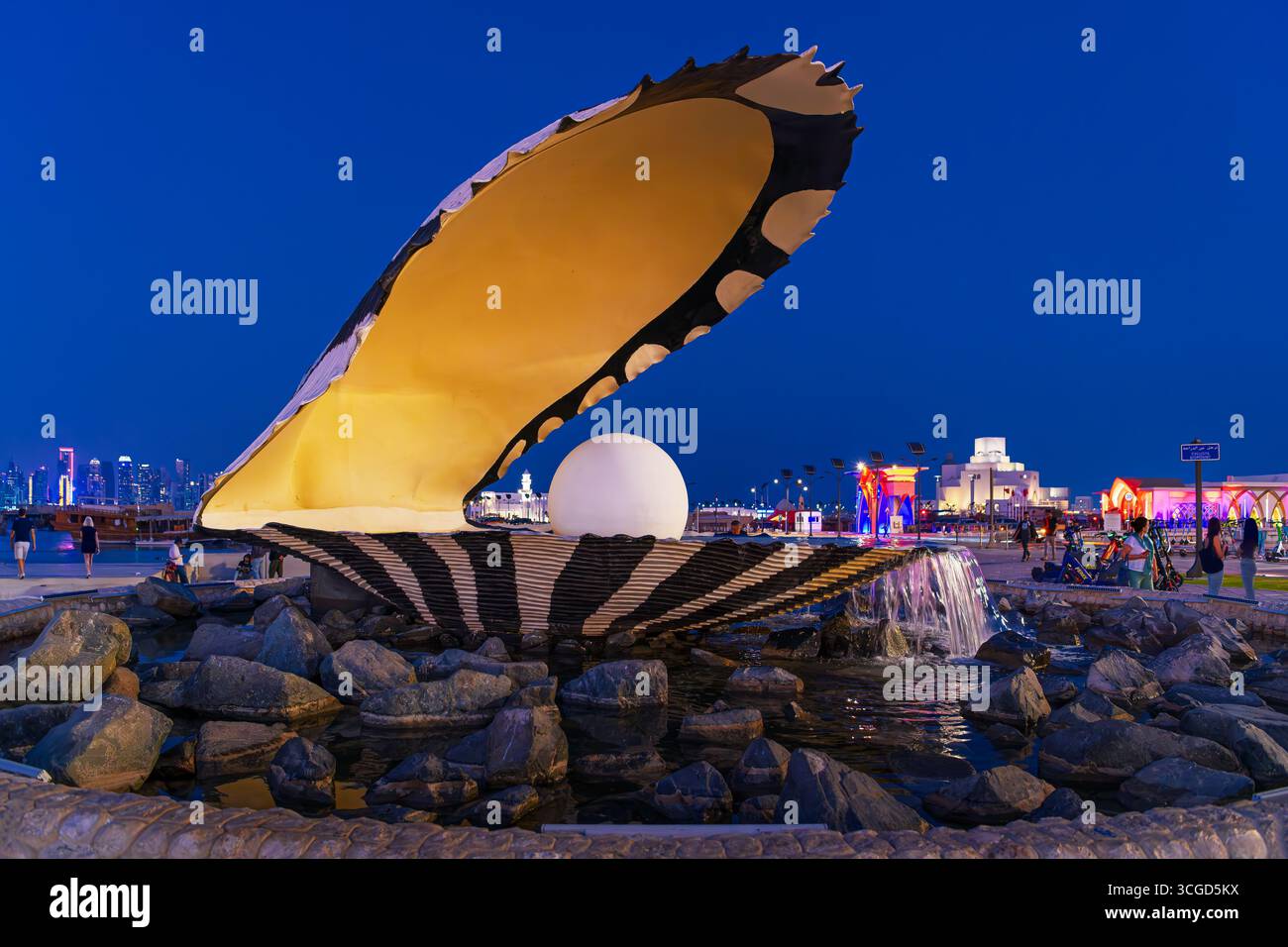 Vista serale del Monumento delle Perle illuminato e della Fontana all'ingresso del porto di Doha sulla Corniche a Doha in Qatar. Foto Stock
