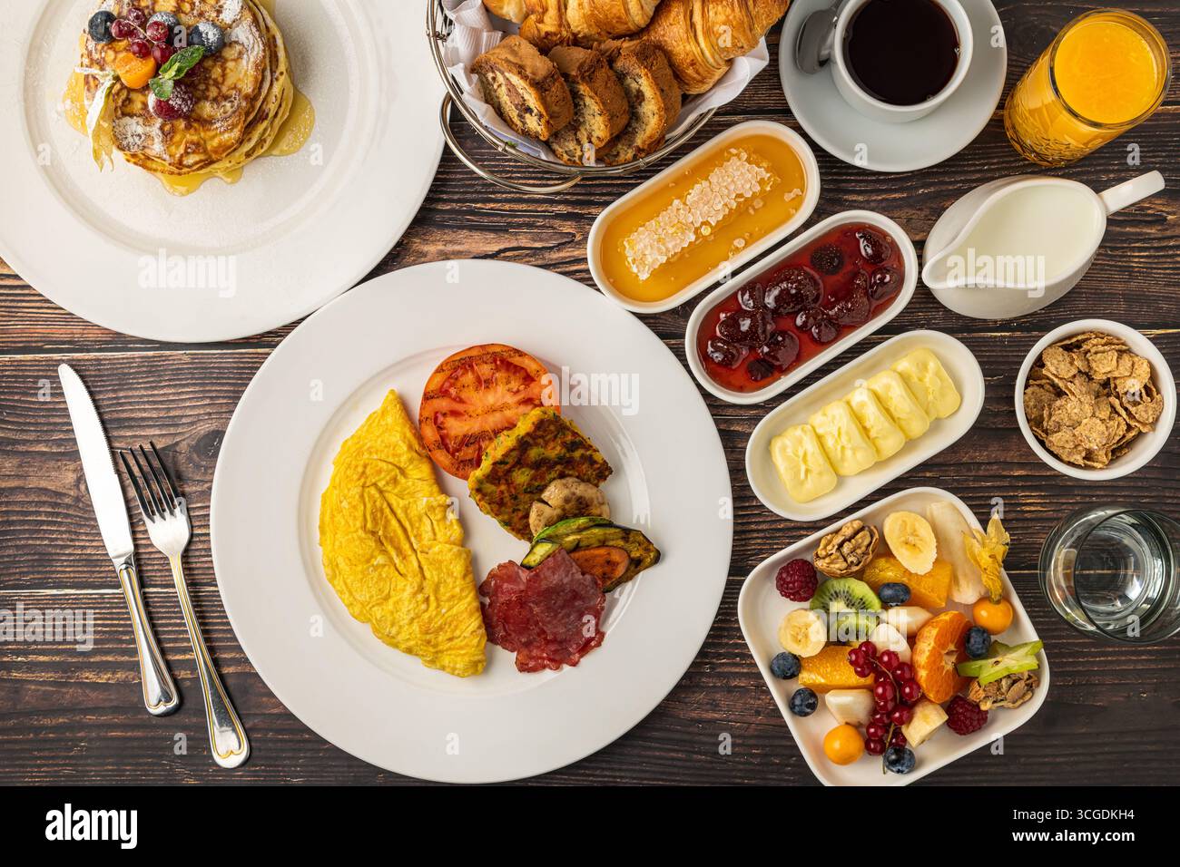 Deliziosa colazione con pancake, omelette, croissant e frutta Foto Stock