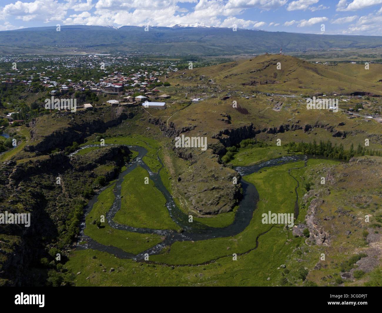 Un fiume si snoda attraverso paesaggi verdi con una città sullo sfondo e colline in lontananza, vista aerea, fiume Kassagh, Oskahan, Oshakan, OTA Foto Stock