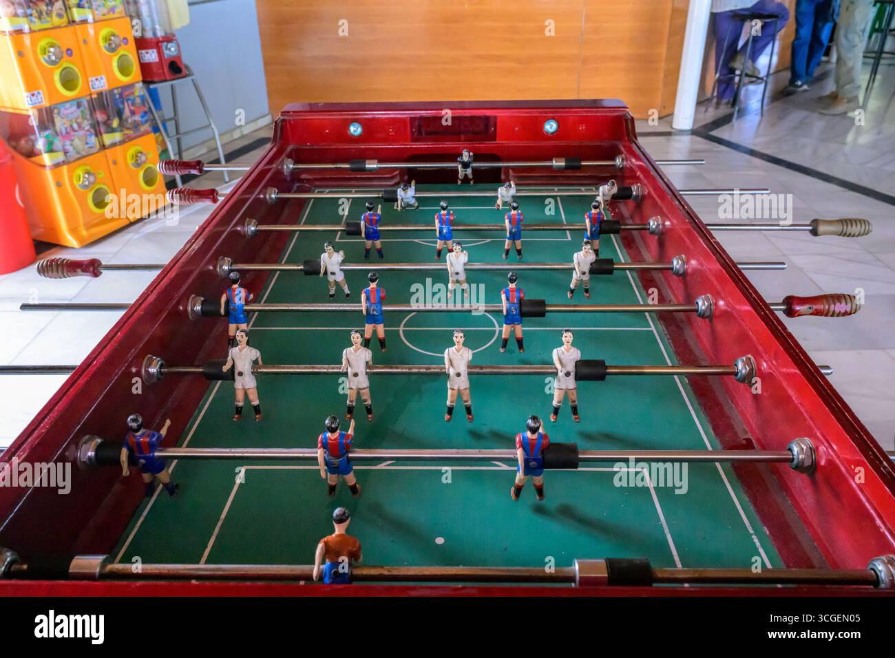 Gli amici potranno assistere a partite di foosball in un bar locale, circondato dal calore del tempo libero del villaggio e della cameratiera a Puebla del Maestre. Foto Stock