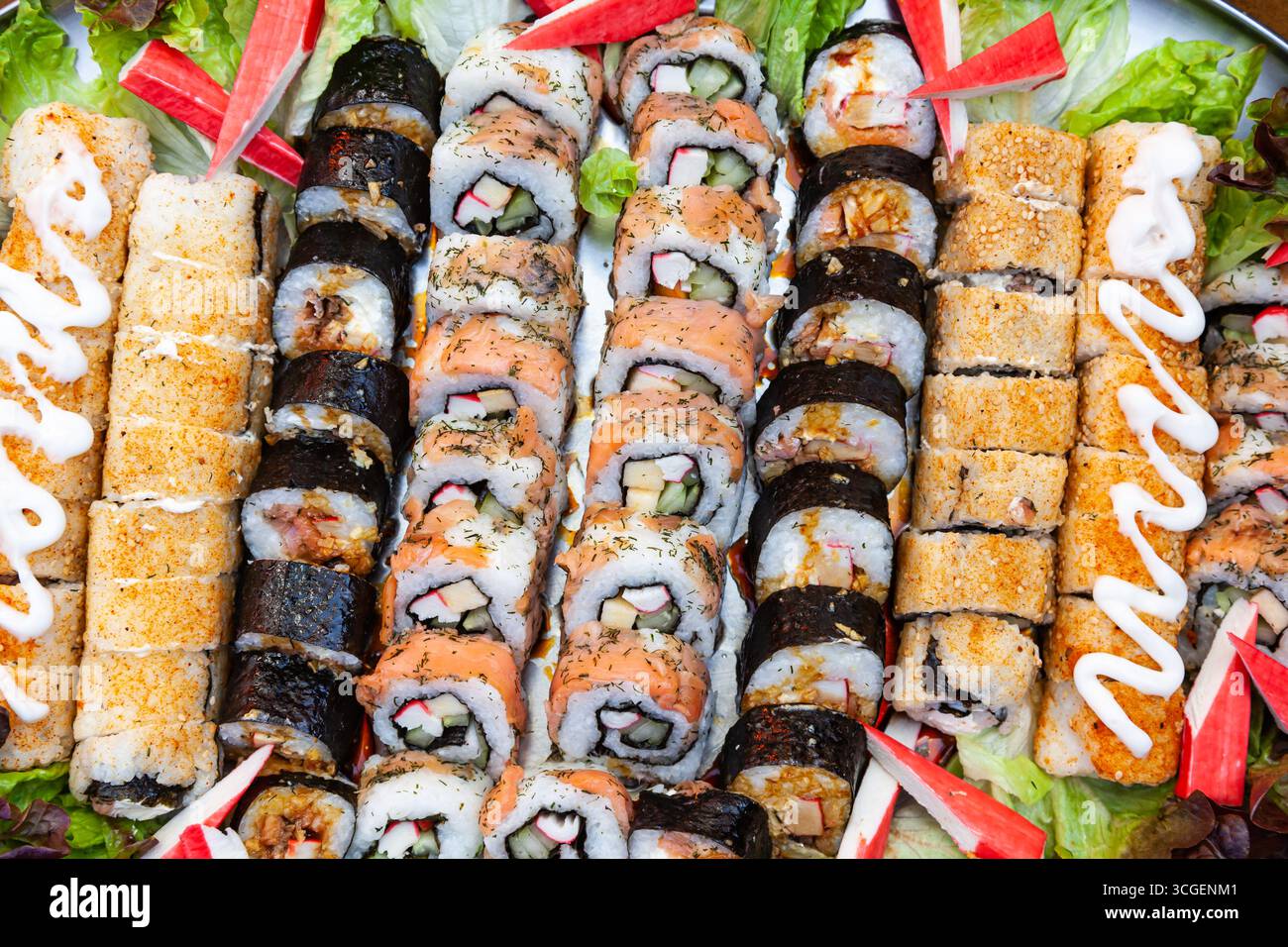 Una grande porzione su un vassoio di panini cotti e sushi di diversi tipi, vista dall'alto. Foto Stock
