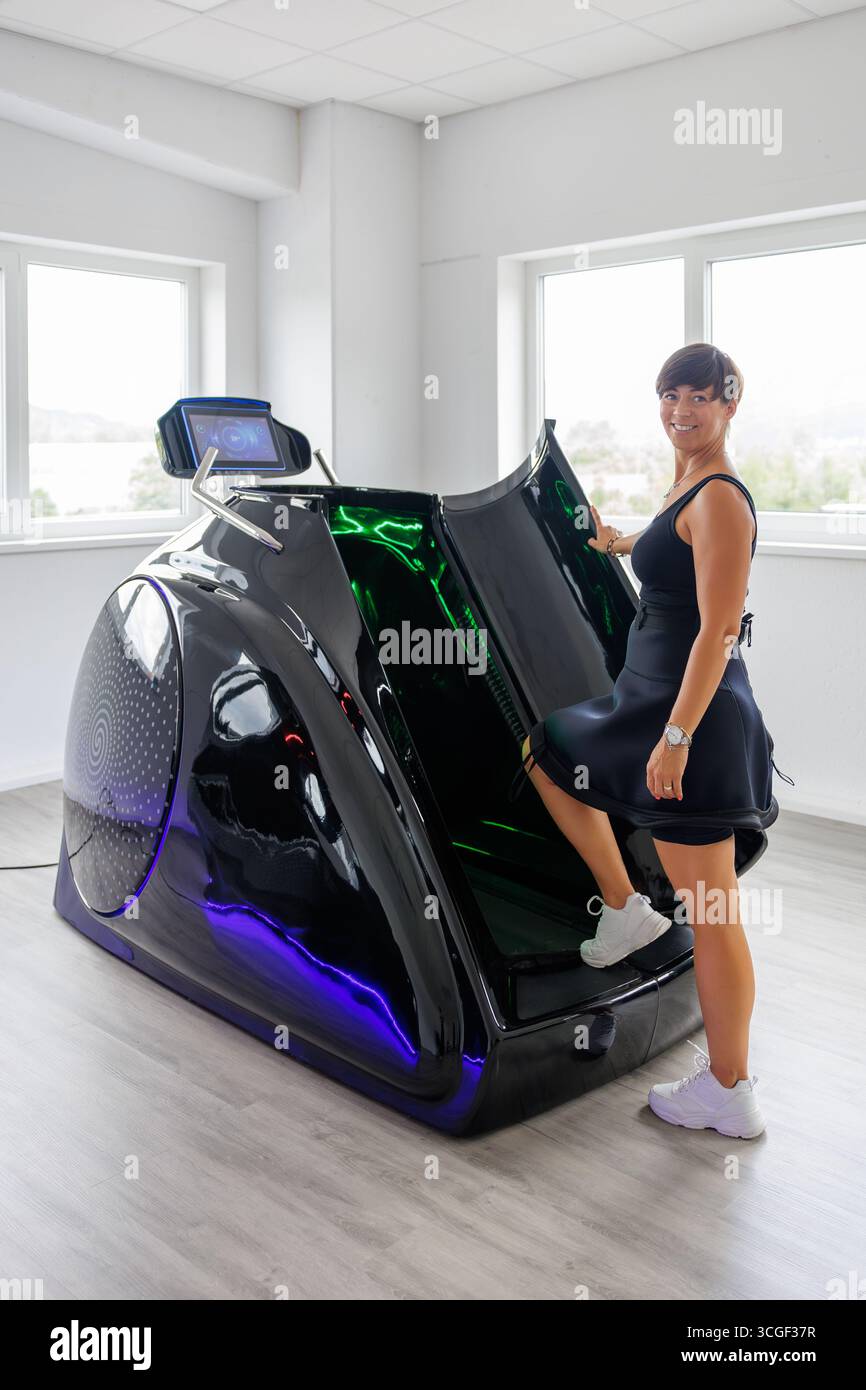 Capsula fitness avanzata che combina tapis roulant sottovuoto e riscaldamento a infrarossi per allenamento cardio, dimagrimento, disintossicazione e cura della pelle in uno studio moderno Foto Stock